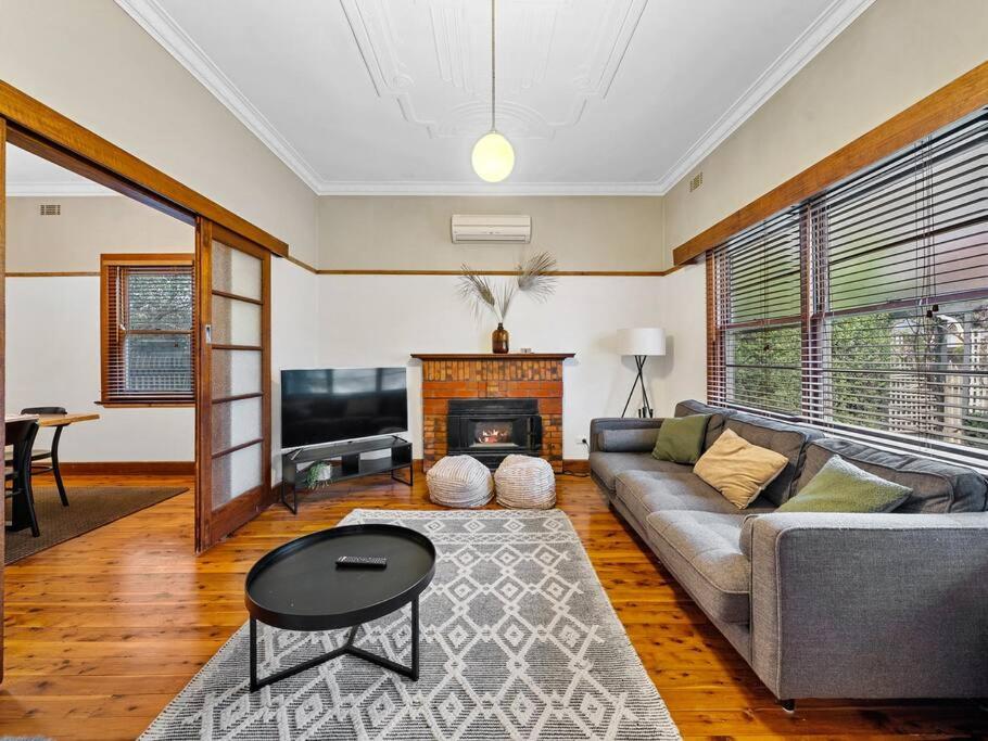 a living room with a couch and a fireplace at 'YANALEN COTTAGE' in Myrtleford