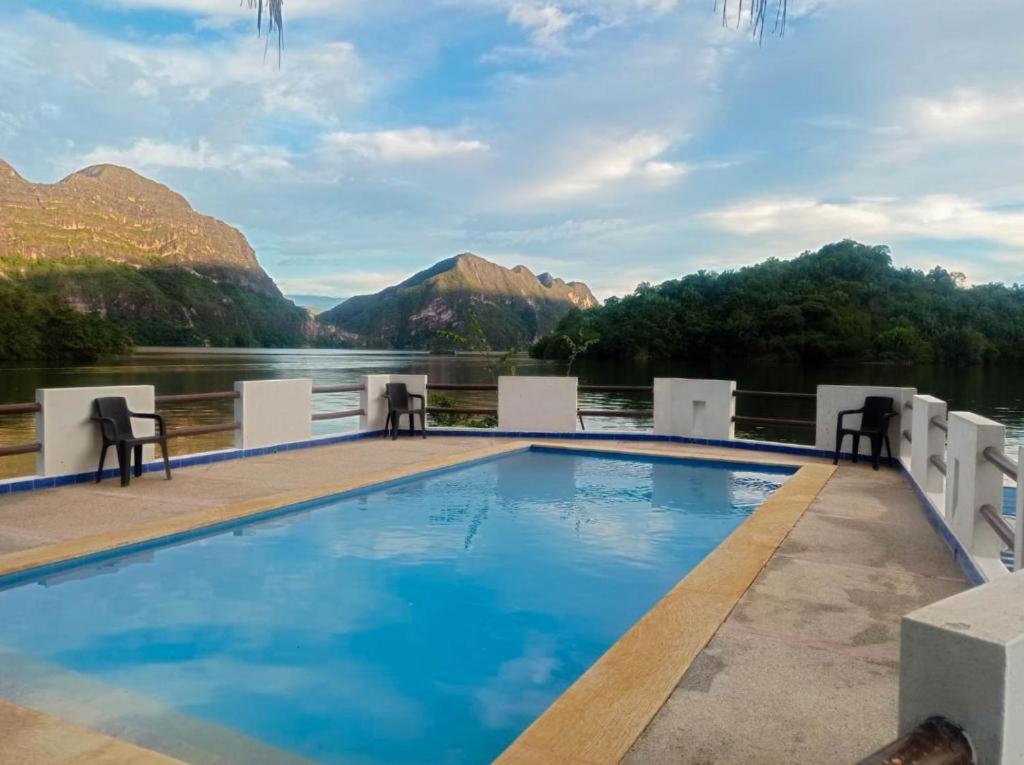 una piscina en un complejo con montañas en el fondo en Cabaña La Bukana campestre, en Prado