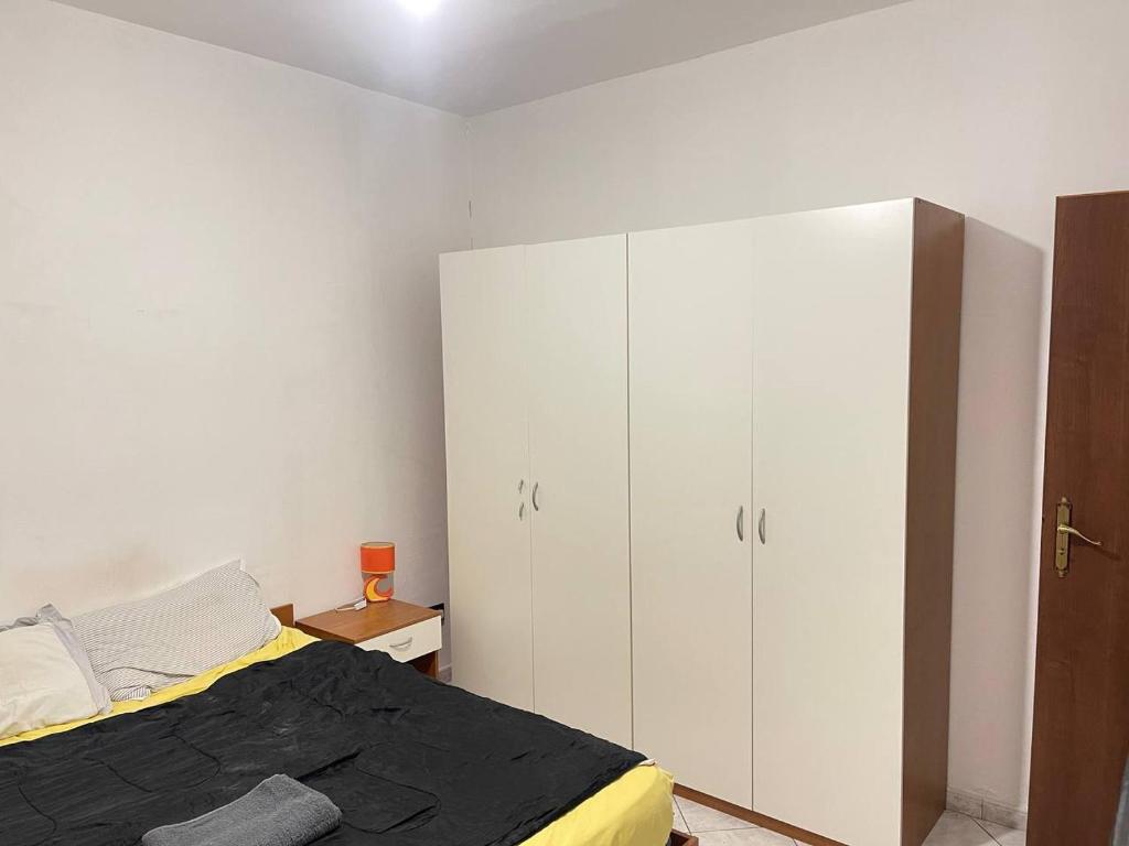 ein Schlafzimmer mit einem Bett und einem großen weißen Schrank in der Unterkunft Marina di San Lorenzo Guest House in Marina di San Lorenzo