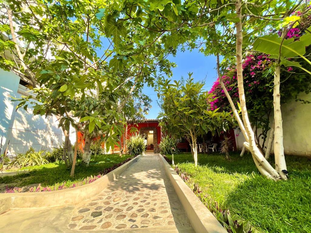 a walkway in front of a house with trees at Casa Hospedaje Pacasmayo in Pacasmayo