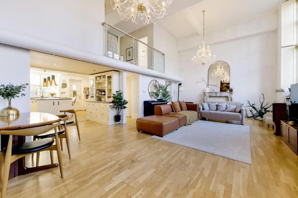uma sala de estar com um sofá e uma mesa em 3BDR Extremely rare luxury loft maisonette em Londres
