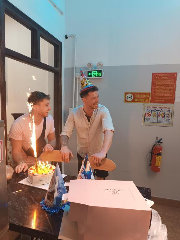 a man and a woman standing in front of a birthday cake at An Homestay & Hostel Motorbikes & Tours in Cao Bằng