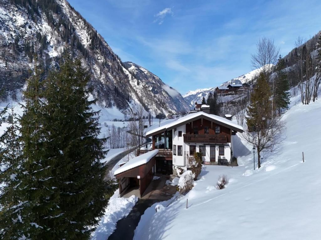 une cabane en rondins dans la neige dans les montagnes dans l'établissement Villa Taube XL, à Bad Gastein