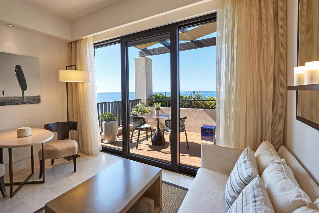 a living room with a couch and a table at The Romanos, a Luxury Collection Resort, Costa Navarino in Romanu
