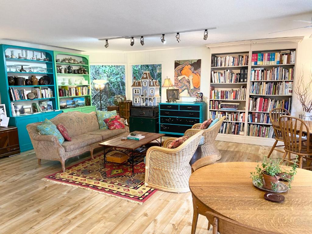 a living room with a couch and chairs and bookshelves at Wisteria Guest House in Ganges