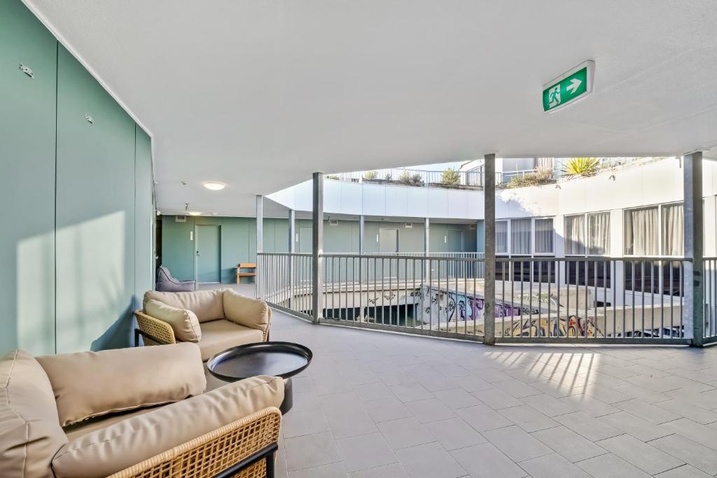 a living room with couches and a balcony at The Urban Newtown in Sydney