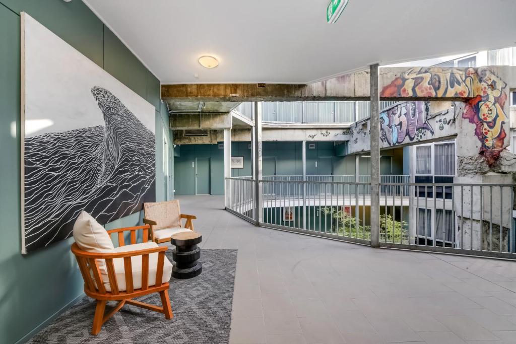 a lobby with a chair and a mural on the wall at The Urban Newtown in Sydney