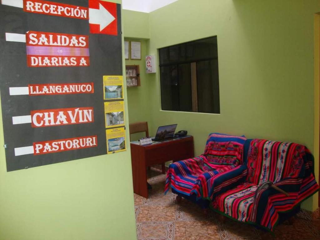 een kamer met een stoel en een bord aan de muur bij Villa hospedaje in Huaraz