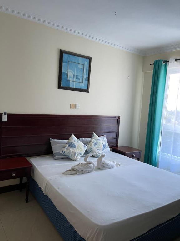 Postel nebo postele na pokoji v ubytování Sunrise Apartments-Nyali