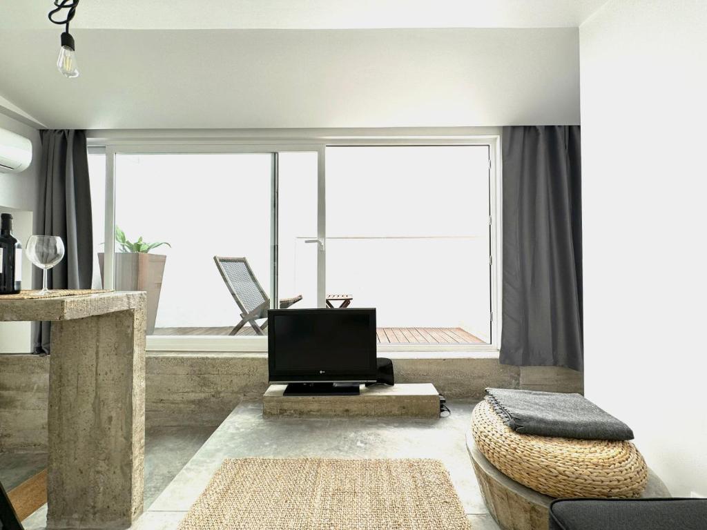 a living room with a tv and a large window at Casa Pátio Boa Vista 4 in Setúbal