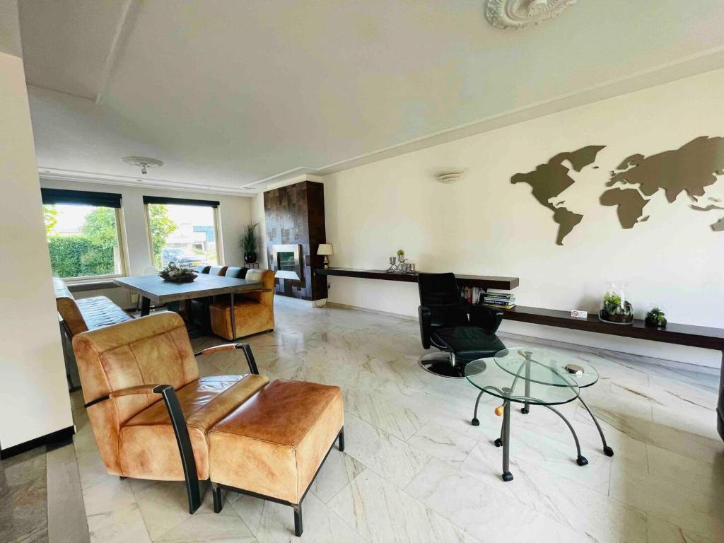 uma sala de estar com cadeiras e uma mesa e um mundo na parede em House Xxl Free Parking 3 Bedrooms em Tilburg