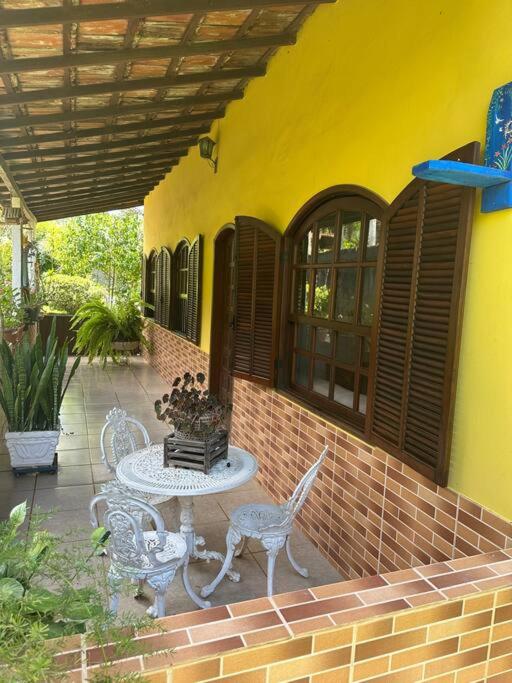 a patio with chairs and a table on a building at Casa no campo in Bom Jardim