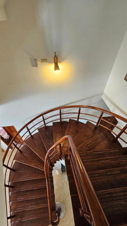 a wooden spiral staircase in a building with a light at Sea Front Homestay in Magong