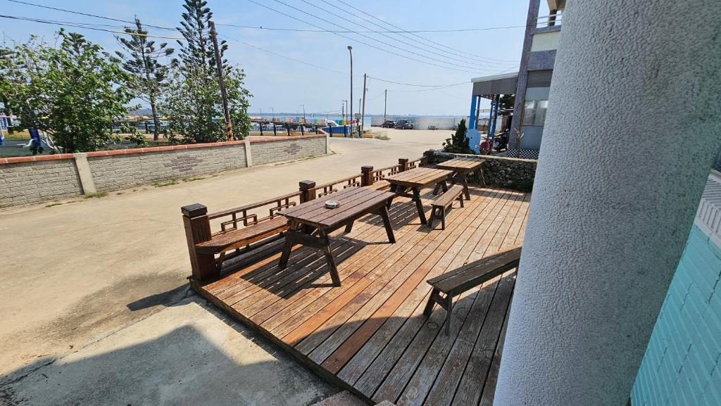 a group of benches sitting on a deck with a building at Sea Front Homestay in Magong