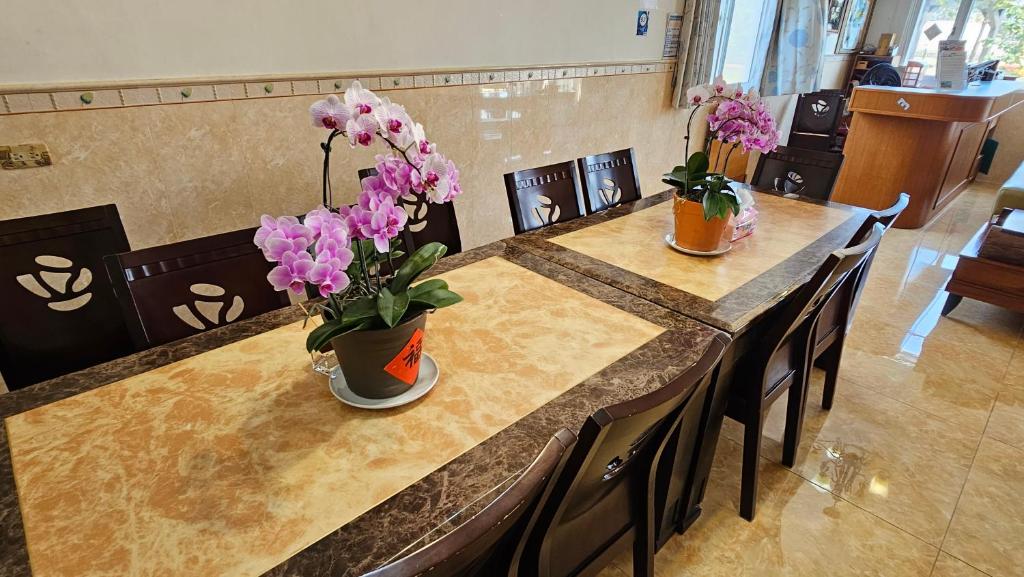 a table with two vases of flowers on it at Sea Front Homestay in Magong