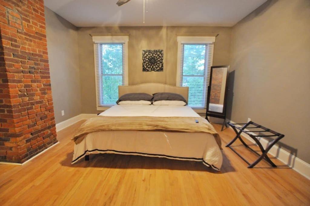 duże łóżko w pokoju z ceglaną ścianą w obiekcie The Troubadour- Location Location w mieście Columbus