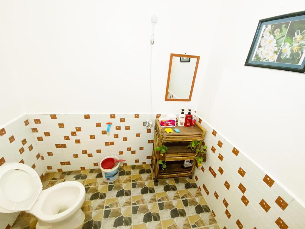 a bathroom with a toilet and a mirror at Battambang Eco Stay in Phumĭ Ândong Pring