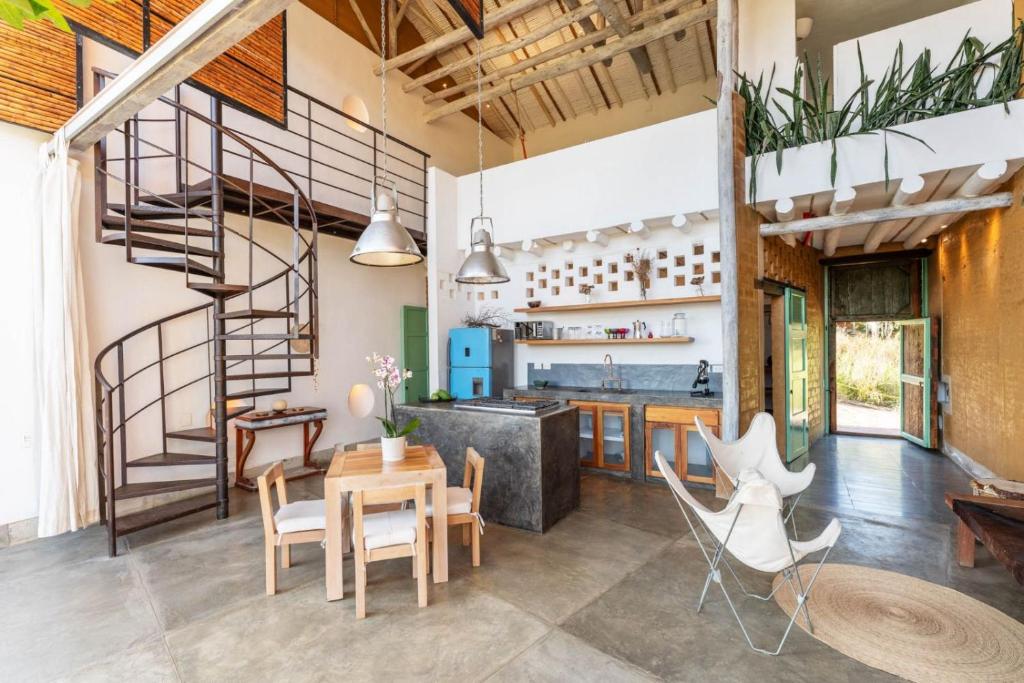 a kitchen and dining room with a spiral staircase at LOFT SAJA. Diseño en tapia pisada contemporáneo in Barichara