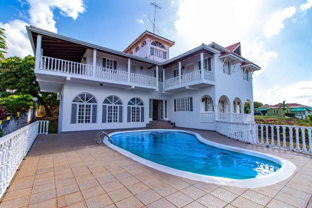 a house with a swimming pool in front of it at Villa Amore Jamaica - Between Montego Bay & Ochi Rios Includes Cook in Discovery Bay