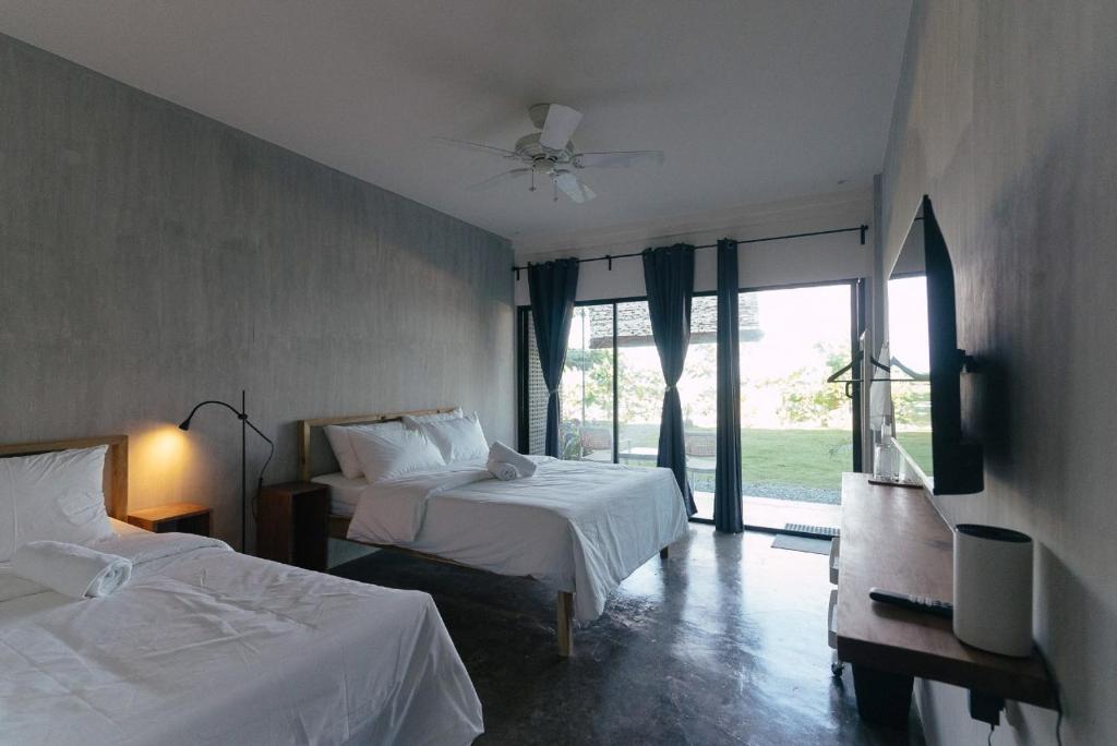 Un pat sau paturi într-o cameră la Katig Beachfront Boutique Hotel