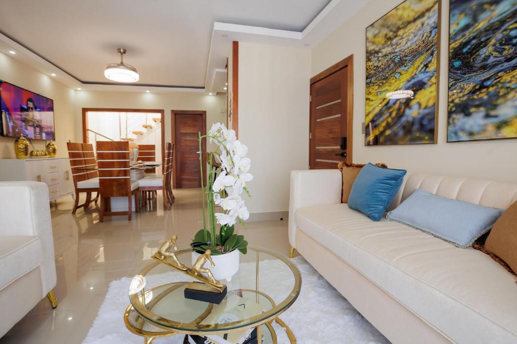 ein Wohnzimmer mit einem weißen Sofa und einem Glastisch in der Unterkunft Luxury Penthouse in San Francisco de Macorís