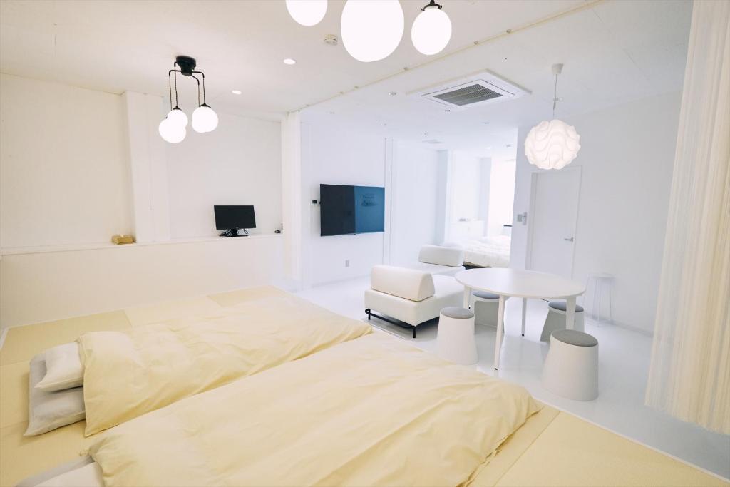 高知的住宿－「まちのアトリエ」STAY UWU 004，白色卧室配有床和桌子