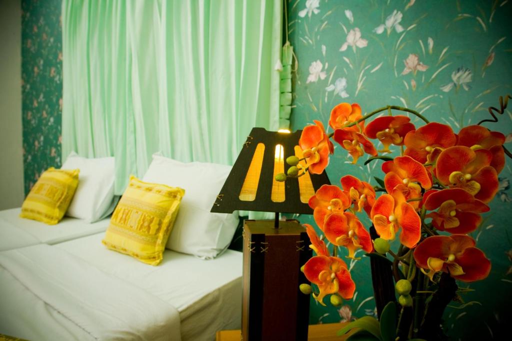 1 dormitorio con 1 cama y un jarrón de flores en Huaykhakhaeng Country Home Resort, en Ban Rai