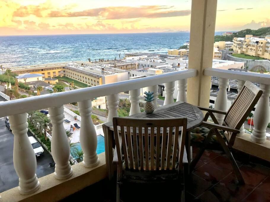 d'un balcon avec une table et des chaises donnant sur l'océan. dans l'établissement 702 w/ a view at Princess Heights, à Dawn Beach