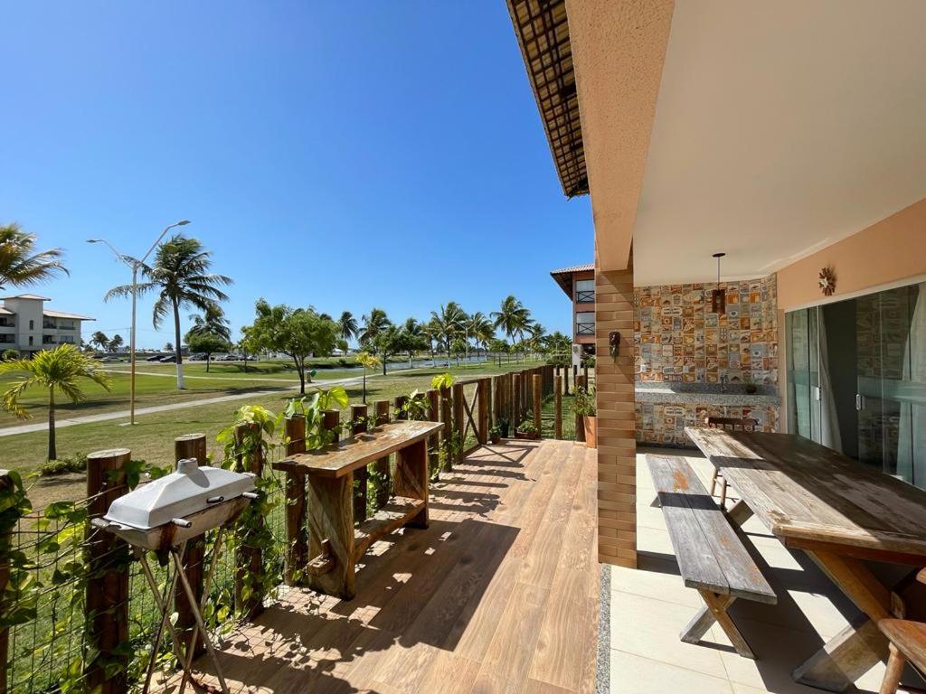 patio z drewnianymi ławkami i kominkiem w obiekcie Casa Térrea - Villa das Águas - Praia do Saco w mieście Estância