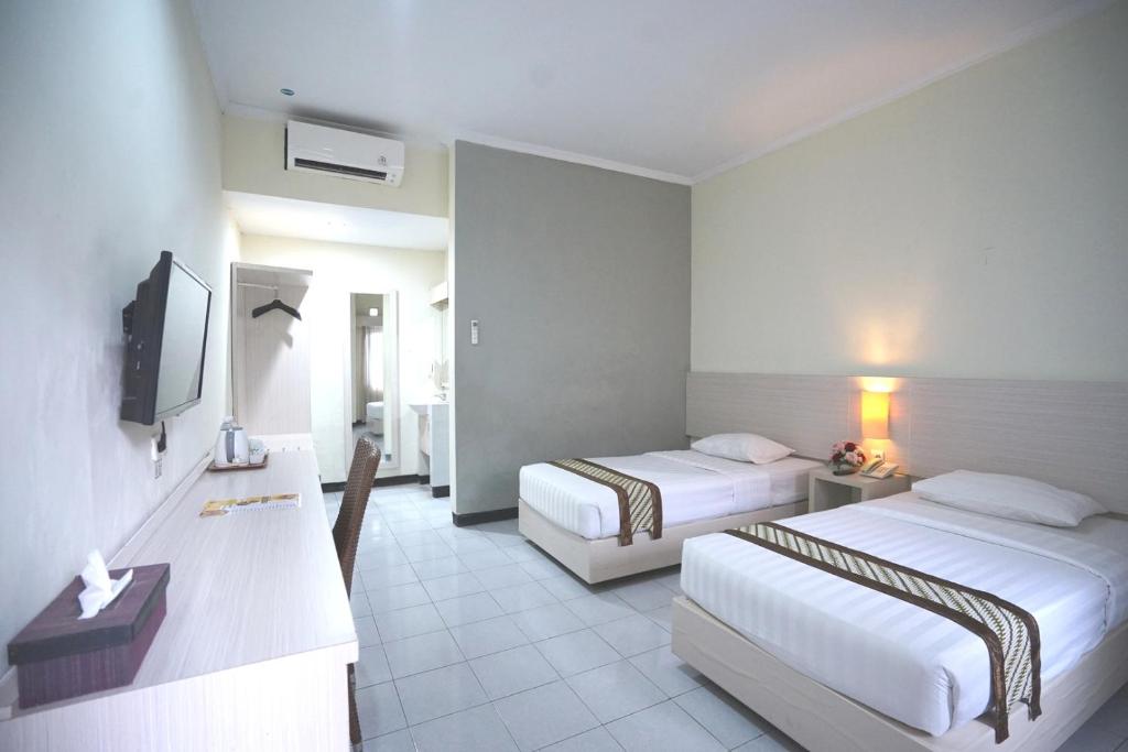 Letto o letti in una camera di Cakra Kusuma Hotel