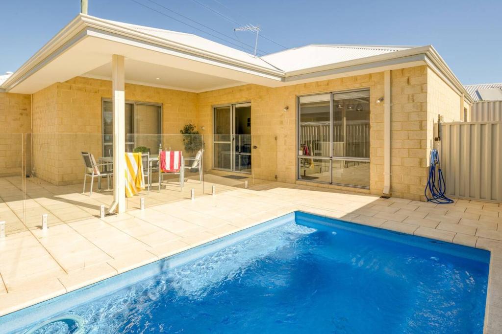 a swimming pool in front of a house at Belmont Beauty - Relaxing Poolside Stay for Families in Perth