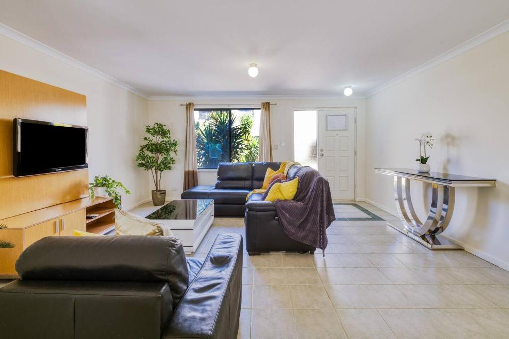 パースにあるBelmont Comfort - Central and Light-filled Stayのソファとテレビのあるリビングルーム