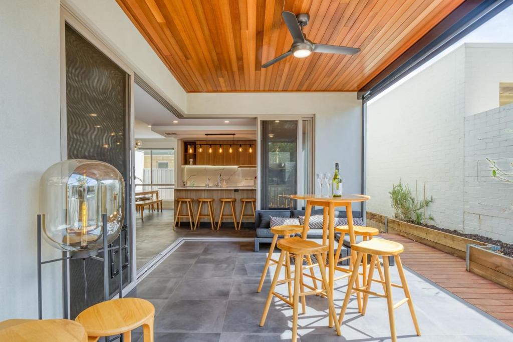 a kitchen and dining room with wood ceilings and stools at Como Sora - A Breezy Tranquil Oasis on the Coast in Perth