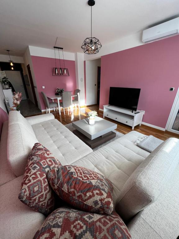 uma sala de estar com um sofá e uma televisão em Kanna Apartments - Bulevar - Free Parking em Sarajevo