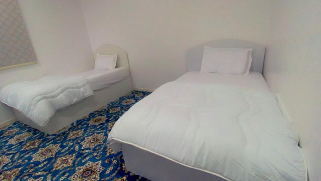 una piccola camera con letto bianco e aasser di Madinah Daylight Residences a Medina