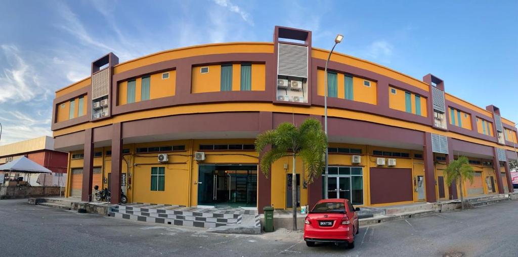 a red car parked in front of a building at Codidik Hotel in Kuantan