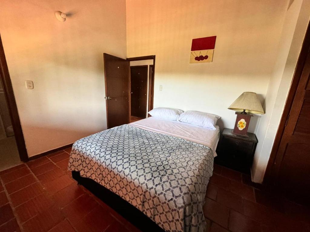 um quarto com uma cama e um candeeiro sobre uma mesa em Finca el Paraíso em Los Santos