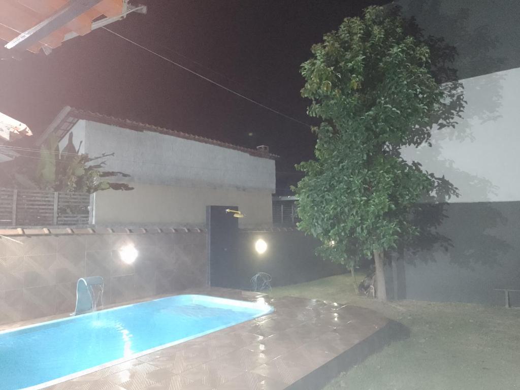 a swimming pool in a yard at night at LINDA CASA DE PRAIA EM PIRATININGA in Niterói