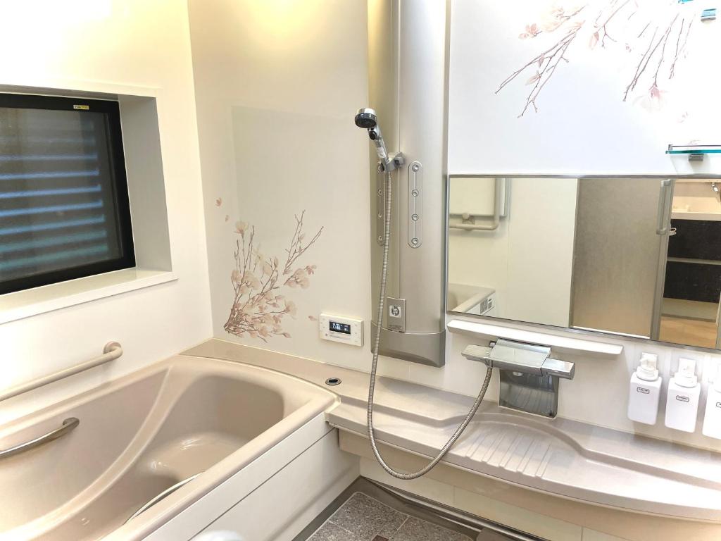 a bathroom with a tub and a tv and a sink at 1日1組限定　和洋折衷 EDOYA in Chiba