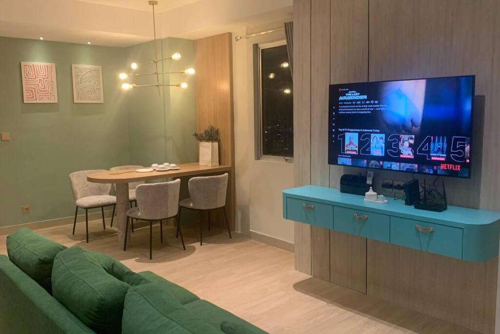 Il comprend un salon doté d'un canapé et d'une table avec une télévision. dans l'établissement 2BR+, Apartement Sudirman Bandung, à Bandung