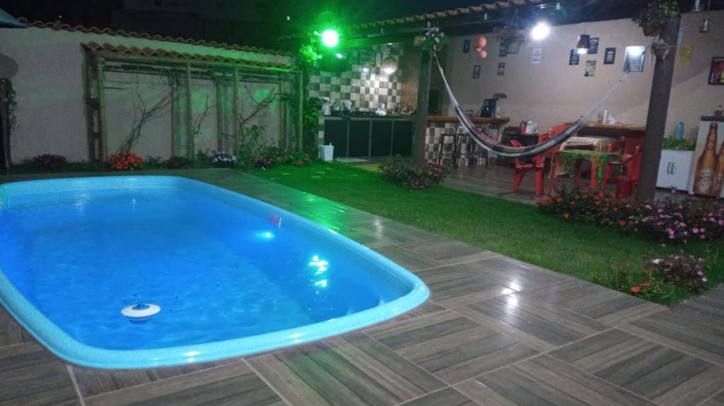 una piscina en un patio trasero por la noche en Hostel Santa Luzia en Viçosa