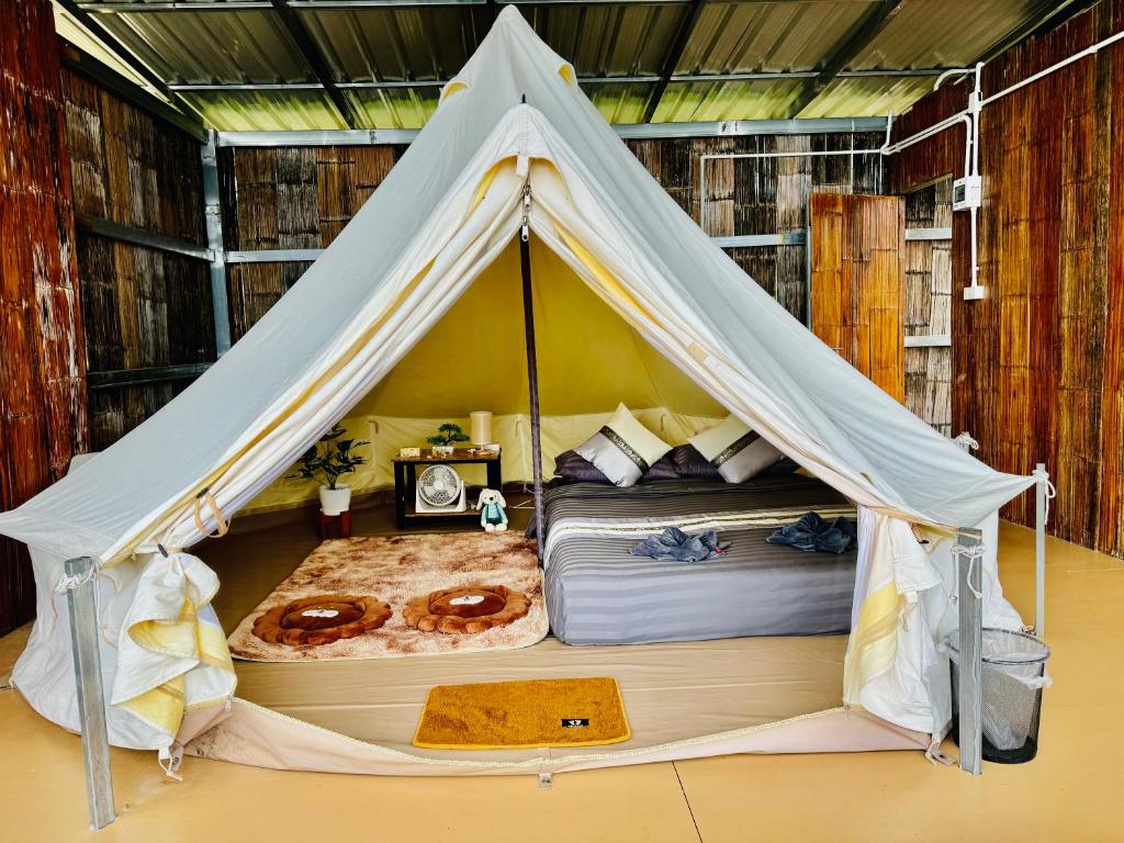 a bedroom with a tent with two donuts in it at หลงฮักเขาแคมป์ปิ้งภูชี้ฟ้า in Ban Huai Khu