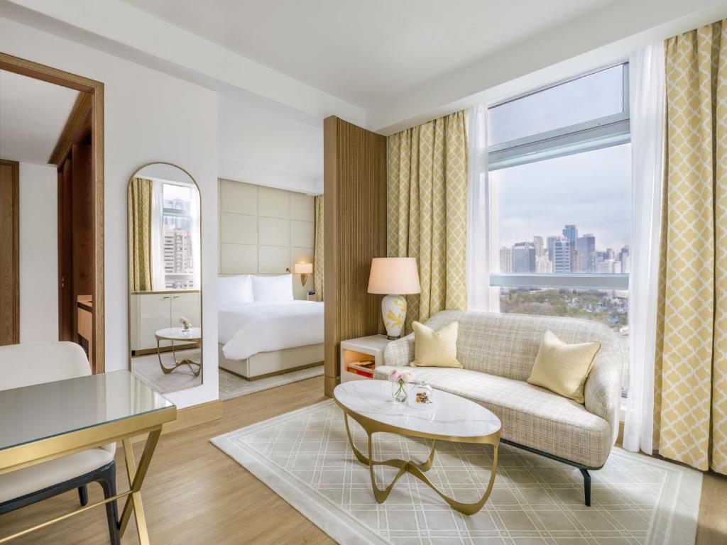 a living room with a couch and a table and a bed at Lanson Place Causeway Bay, Hong Kong in Hong Kong