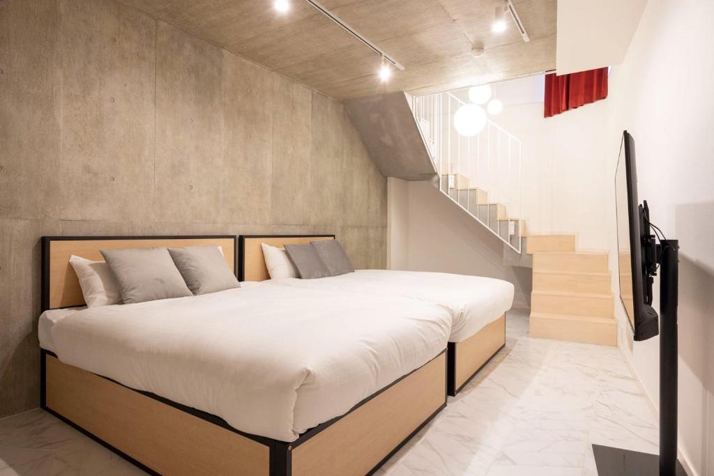 東京にあるLEGALAND Sangenjaya ANNEXの大きなベッドと階段のある寝室