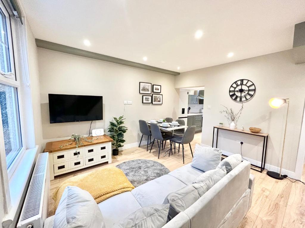 a living room with a white couch and a tv at The Keyfield House - St Albans in Saint Albans