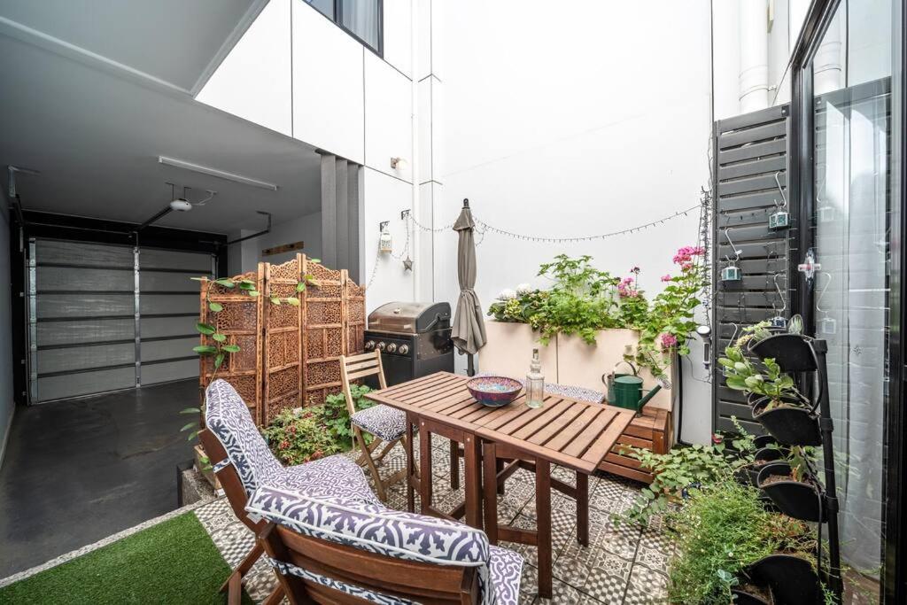 a small patio with a wooden table and chairs at Kashida - Persian-Style Townhouse with Office in Marion