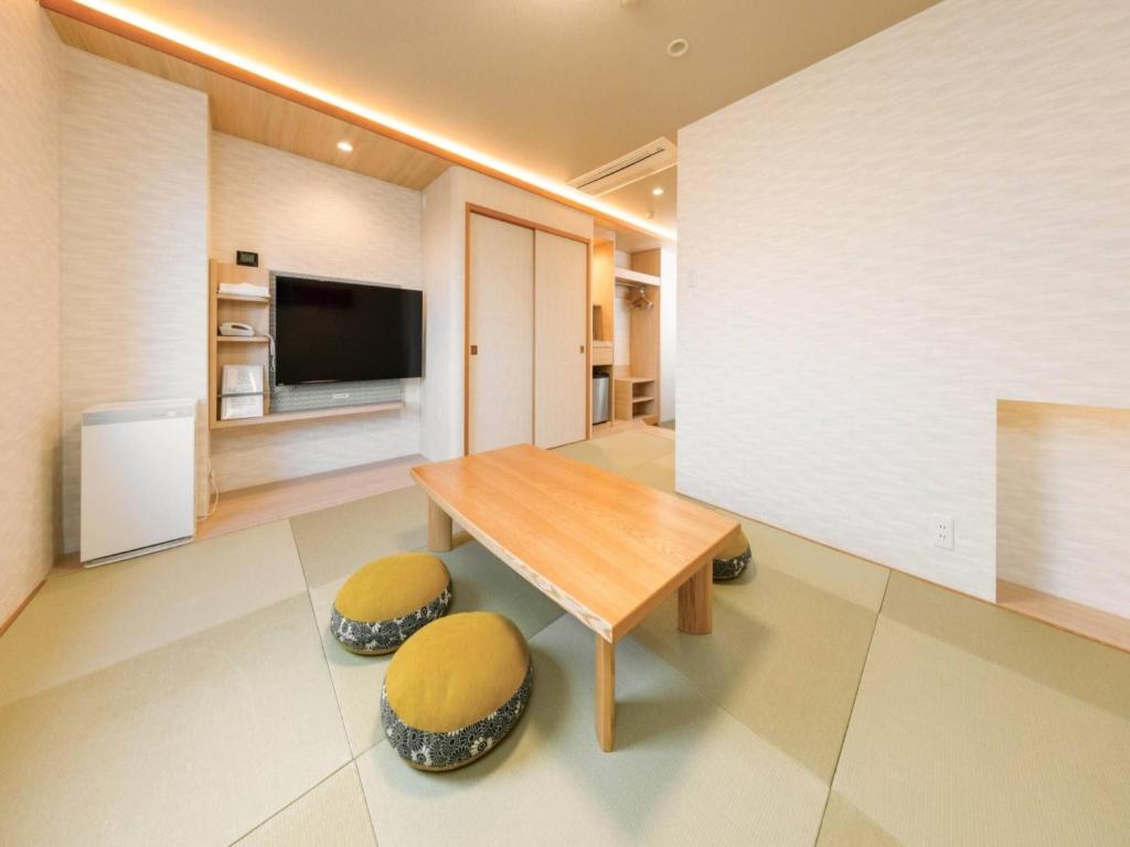 a living room with a wooden table and two stools at Tokai City Hotel - Vacation STAY 83890v in Tokai