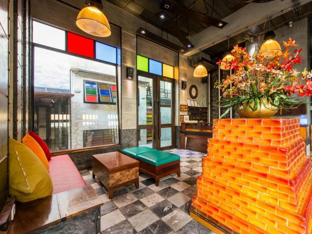 ein Zimmer mit bunten Fenstern und einer Couch und einem Tisch in der Unterkunft Pak Ping Ing Tang Boutique Hotel in Ban Bang Khen (1)