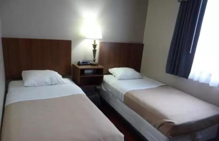- 2 lits dans une chambre d'hôtel avec fenêtre dans l'établissement Alojamentos Rio Verde, à Rio Verde
