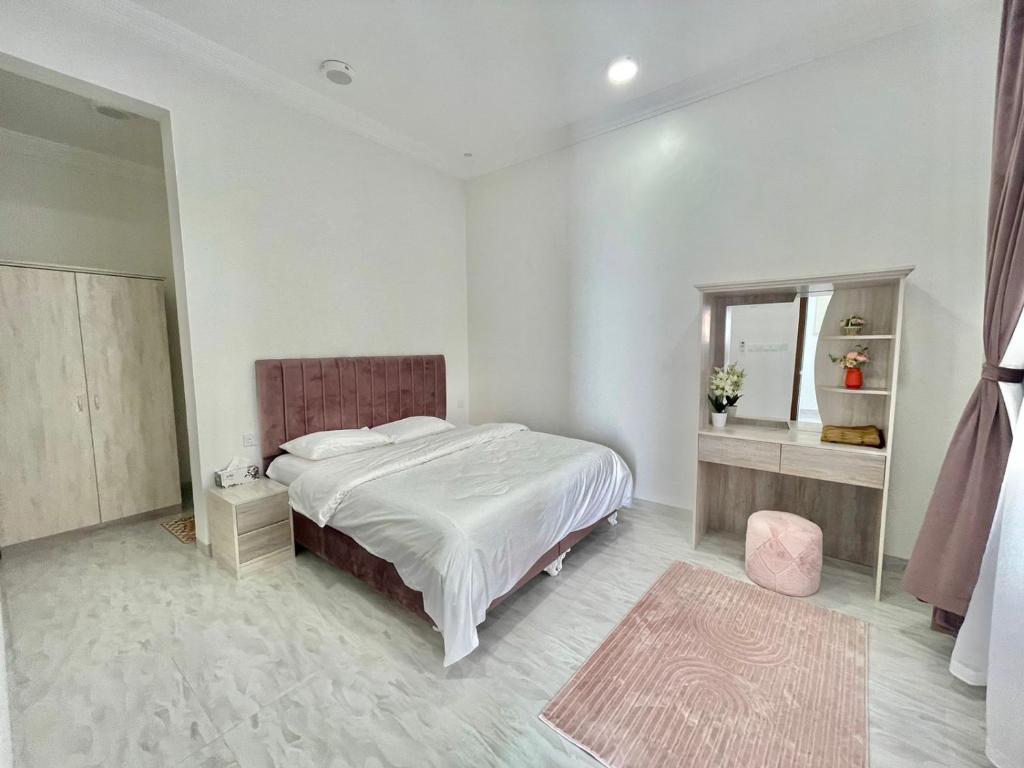 a white bedroom with a large bed and a mirror at AL Rabie Villa, Nizwa Grand Mall in Firq